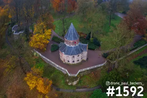 Luchtfoto van de Sint-Nicolaaskapel op het Valkhof in Nijmegen, omringd door gele en oranje herfstbomen