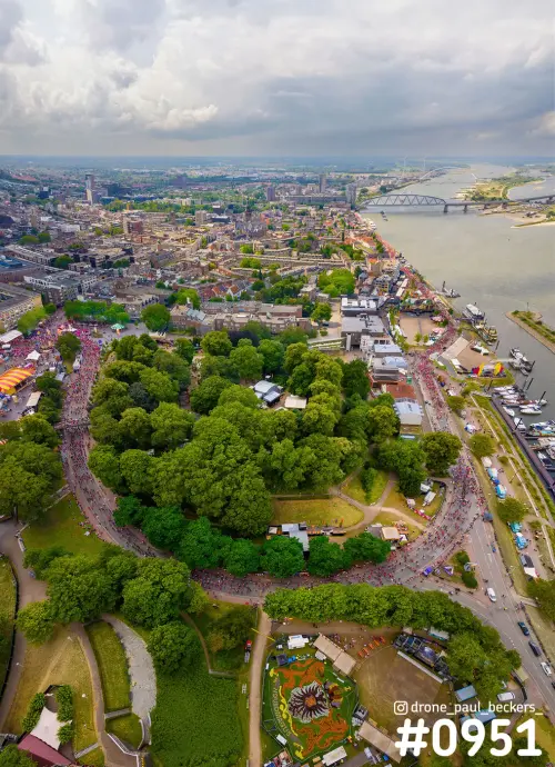 Luchtfoto van het Valkhof gebied in Nijmegen tijdens de Vierdaagse, met menigte langs de route en de Waalkade