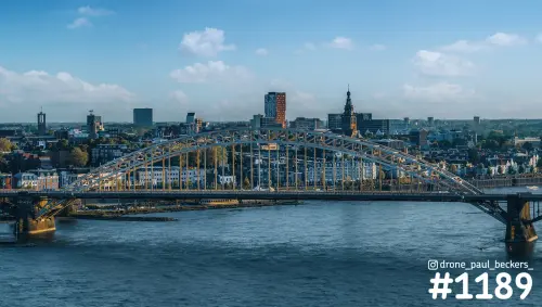 Waalbrug in Nijmegen in warm avondlicht, met de Stevenskerk en de skyline van het centrum achter de rivier de Waal