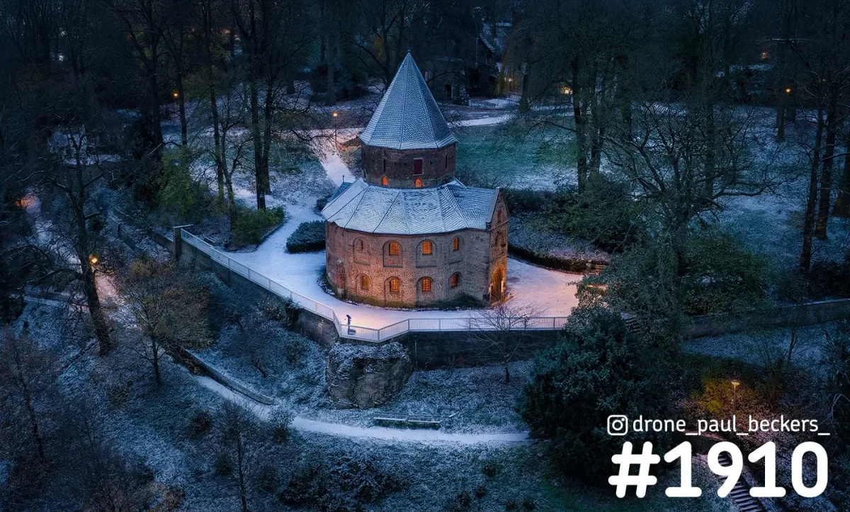 Luchtfoto van de Sint-Nicolaaskapel op het Valkhof in Nijmegen in de winterschemering, met sneeuw en verlichte ramen